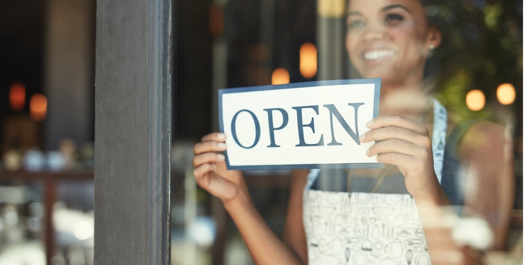 Woman holding OPEN sign